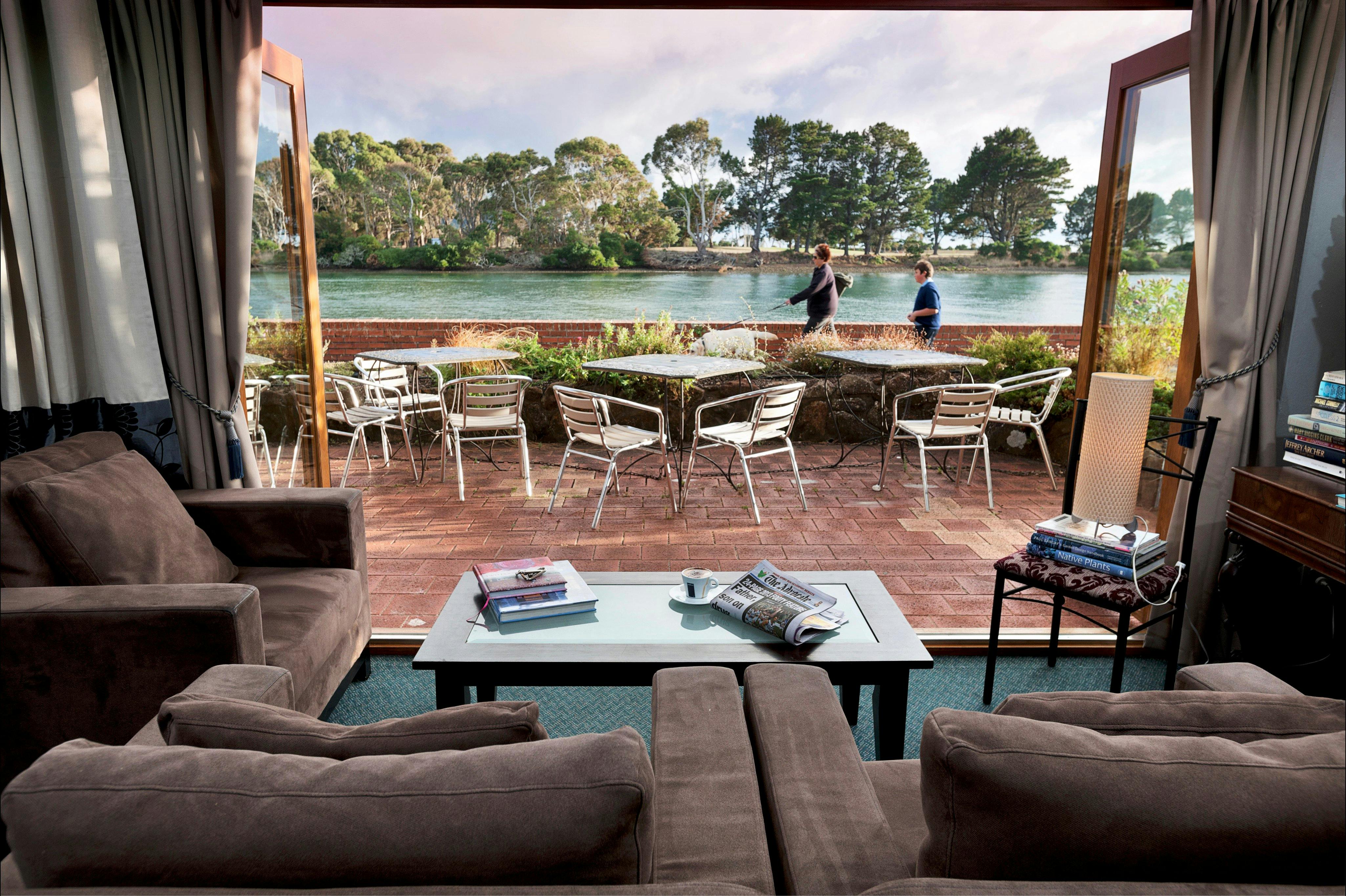 View of the aqua Inglis river from inside the guest lounge, looking out at people walking by.