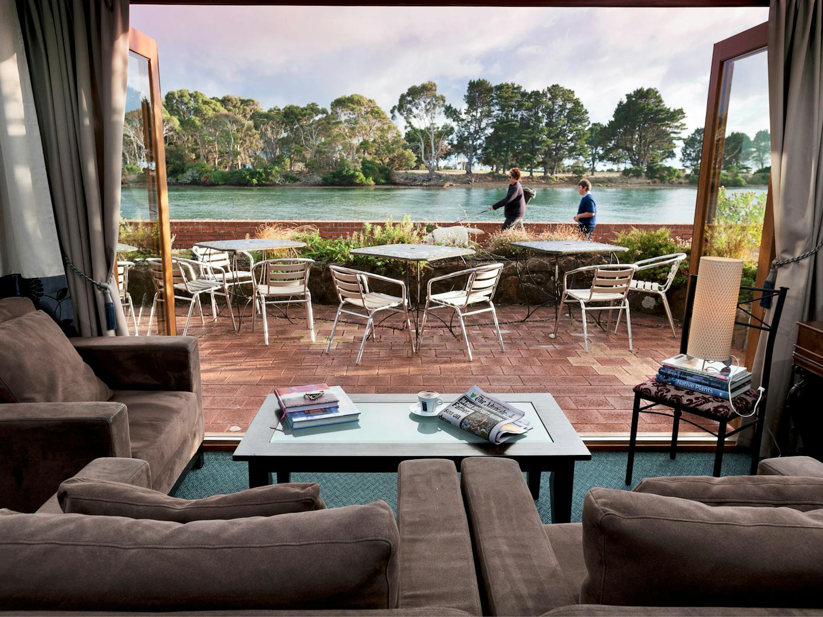 View of the aqua Inglis river from inside the guest lounge, looking out at people walking by.