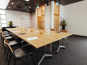 A corporate meeting room with a boardroom style set up.