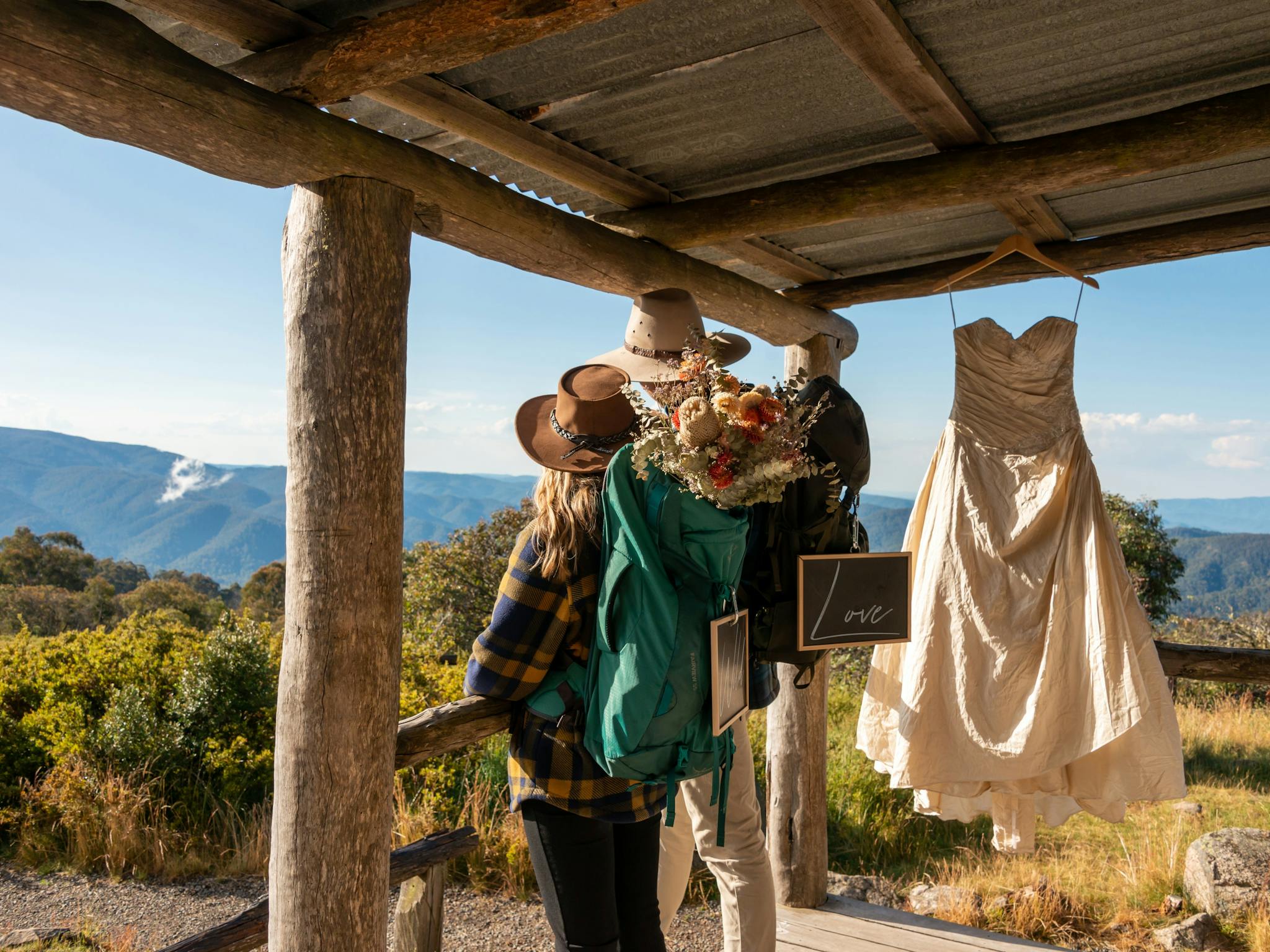 Bride and groom enjoying the views from Craig's Hut with the wedding dress hanging on the porch.