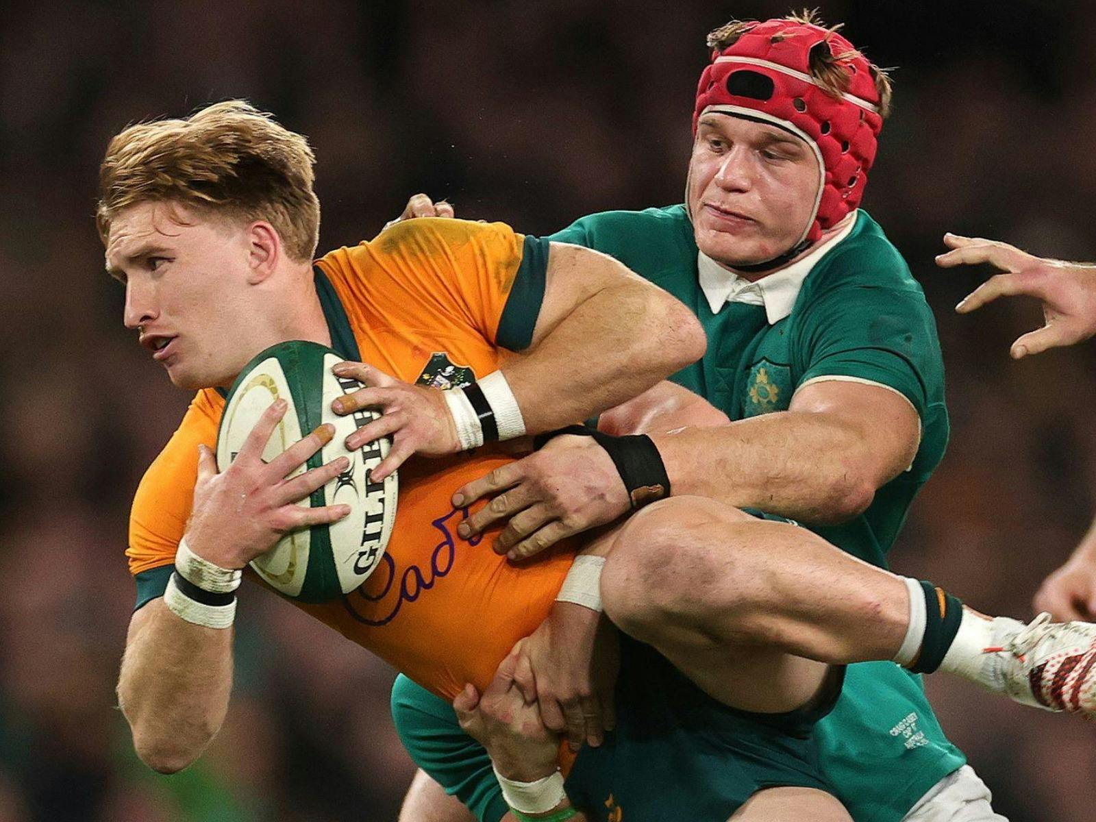 Wallabies player getting tackled by Ireland Rugby player