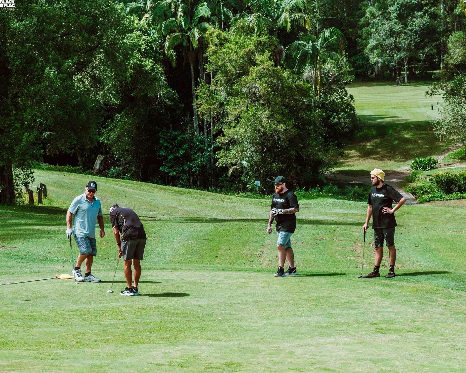 Golfers enjoying a beer and working on their short game.