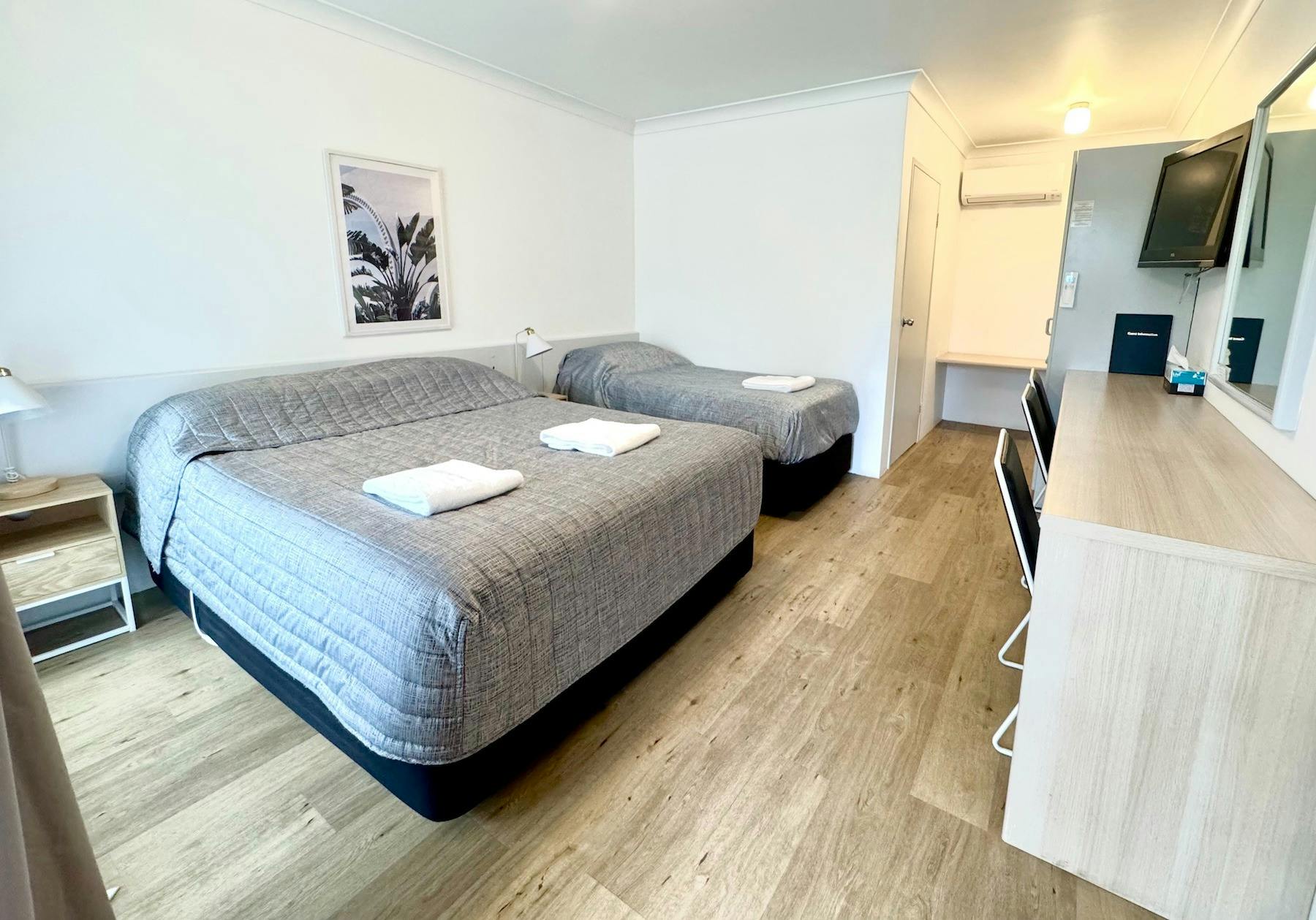 Sutherland Motel with one queen bed and one single bed, bedside tables, television, long work desk