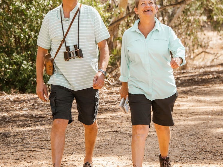 elderly couple walking along a sealed trail past the corowa wetlands