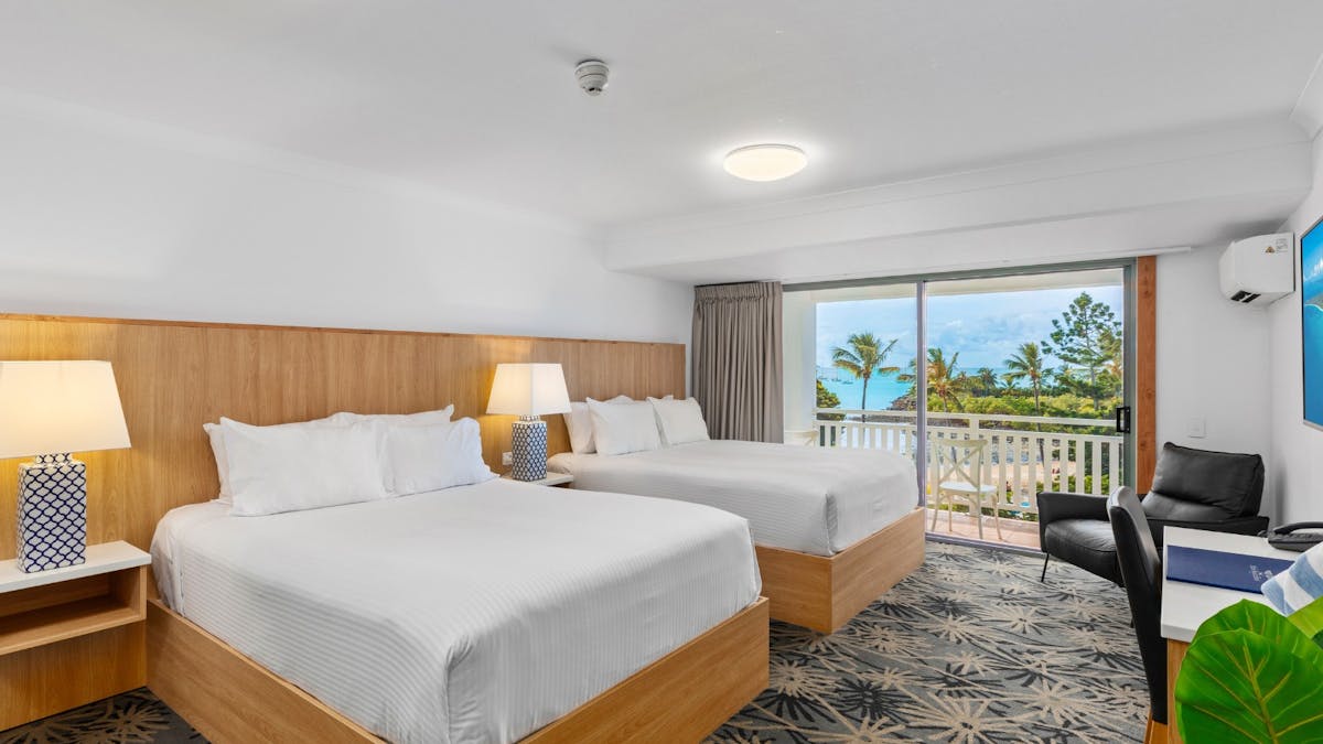 Twin Room at Airlie Beach Hotel featuring two single beds, modern furnishings, and natural light