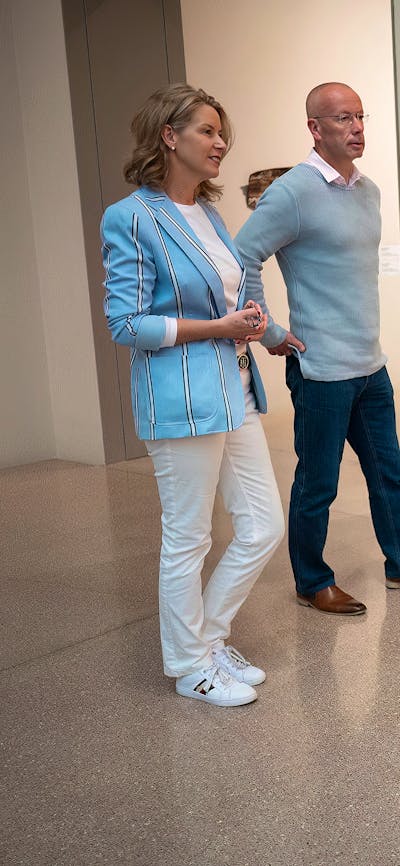 A gallery curator and couple standing in front of an artwork