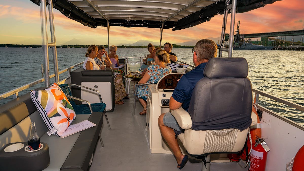 Wide angle of skipper and guests enjoying a stunning sunset on the Trinity Inlet near Cairns