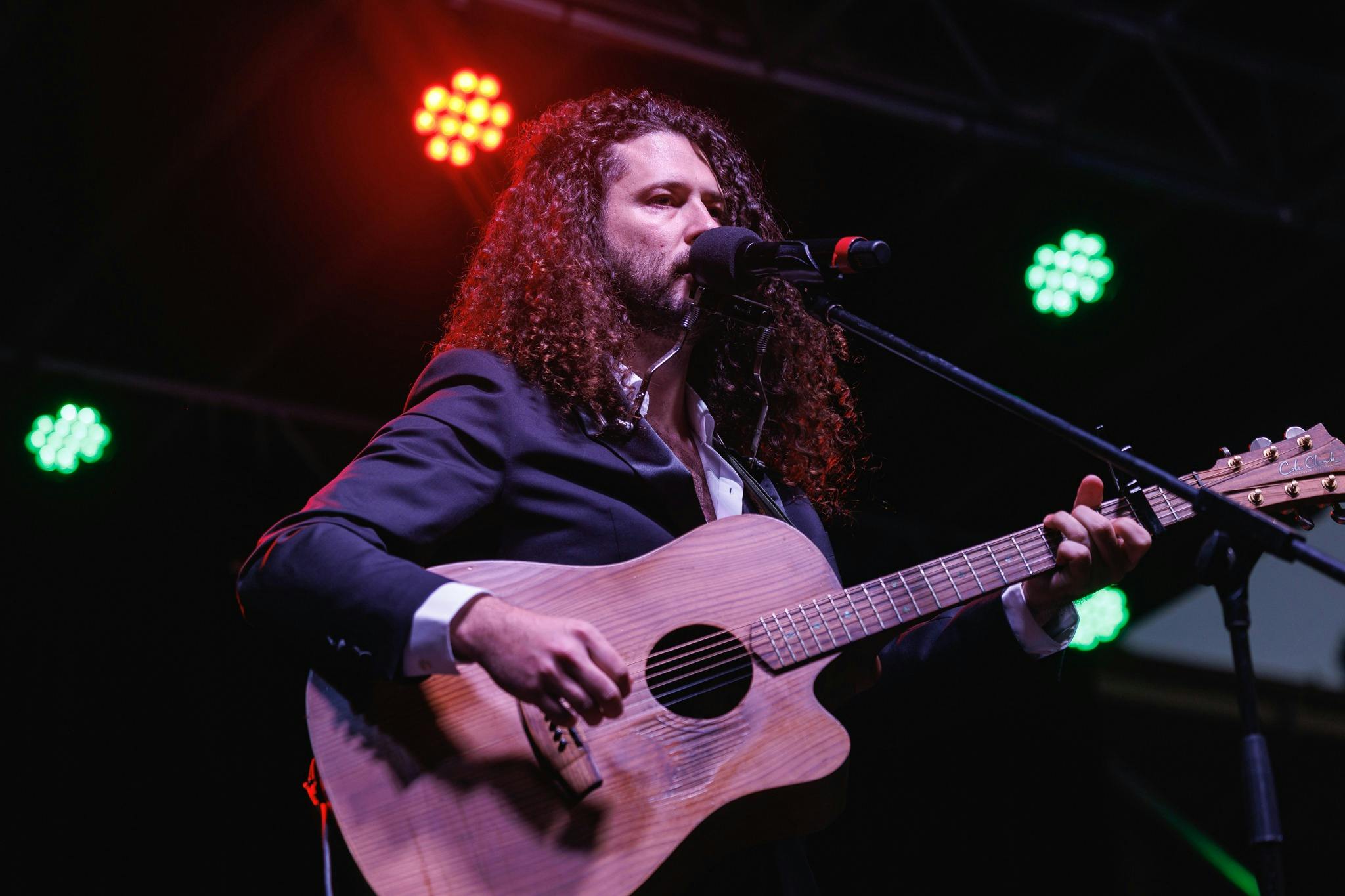 Artisit Luke Biscan performs with guitar on stage