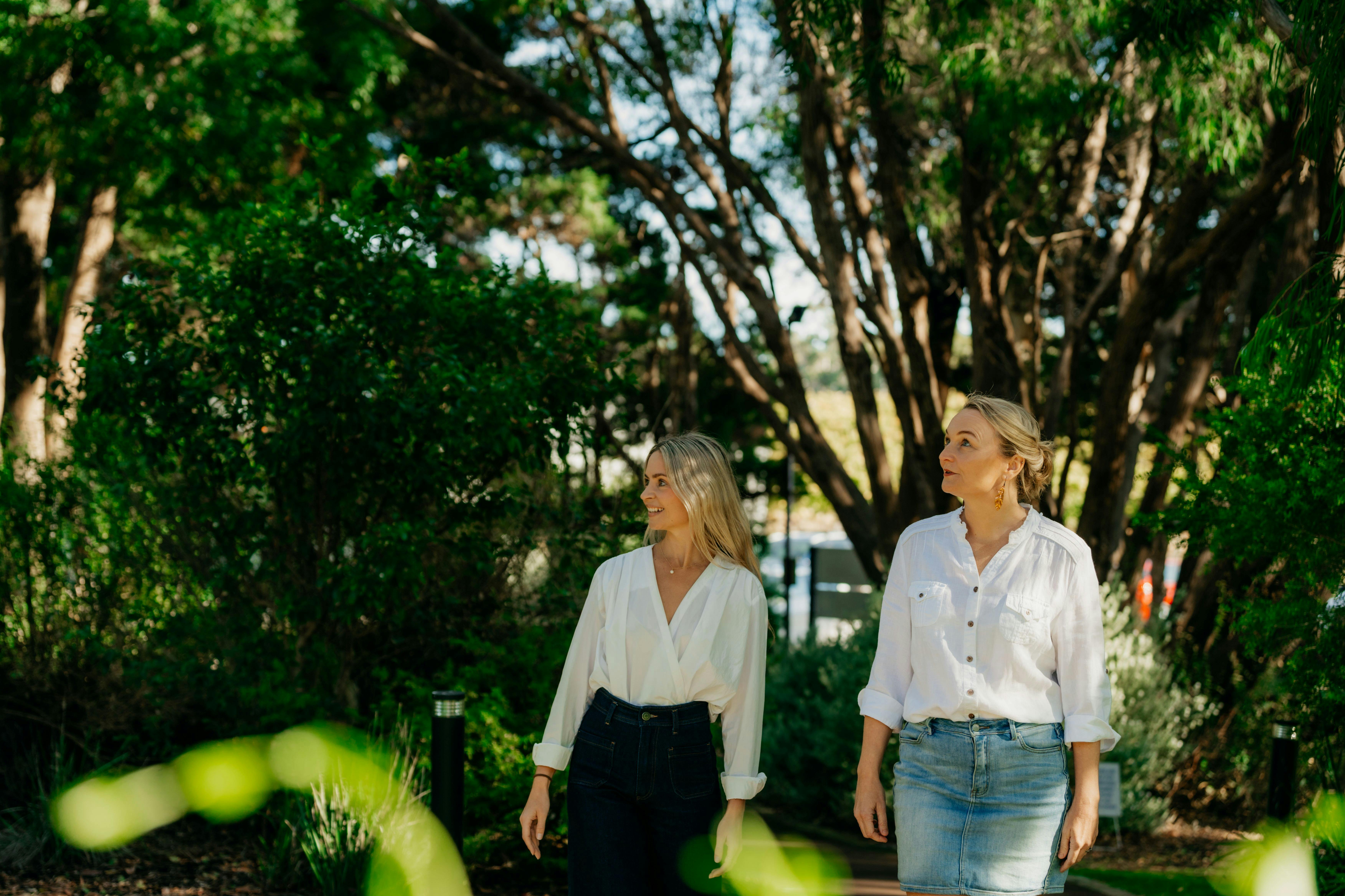 Two women in white shirts walking through the Australian gardens to Cape Mentelle Cellar Door