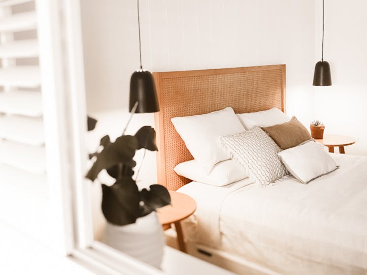 Bed with pillows, pendant lights, indoor plant and window frame