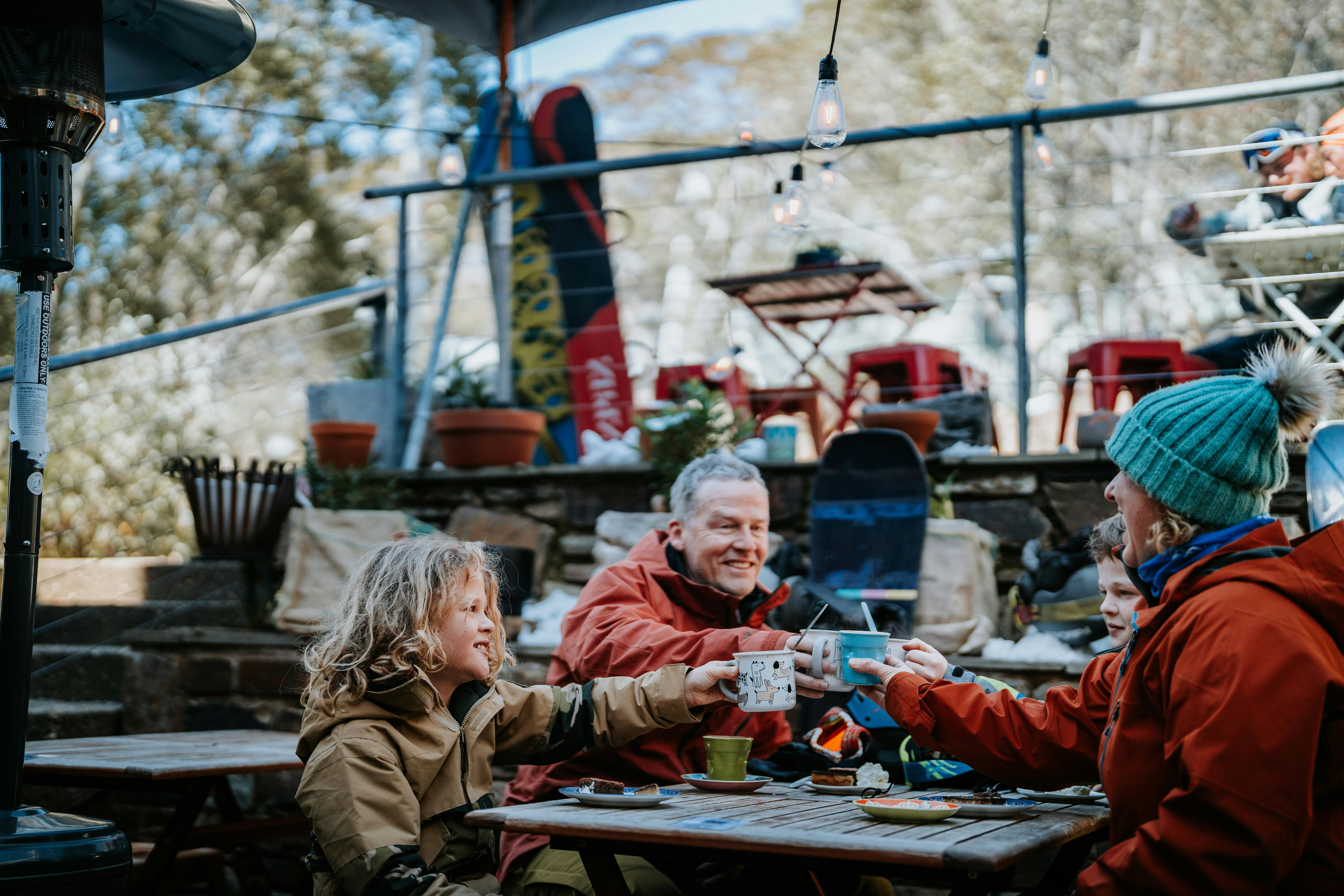 Family drinking hot chocolates on ski break