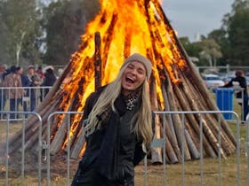 Smiling girl standing in front of bonfire