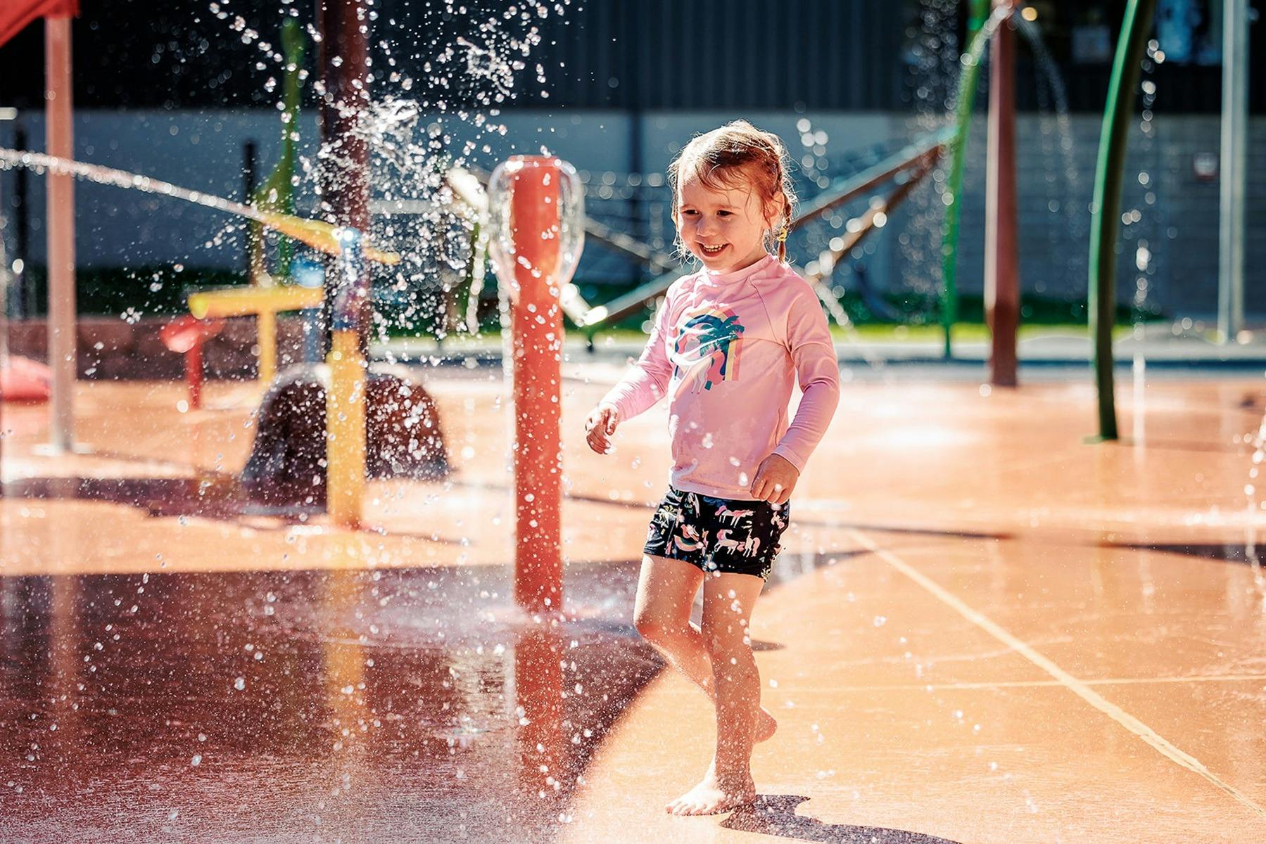 Little girl in a pink top playing having water fun at the Benalla Splash Park