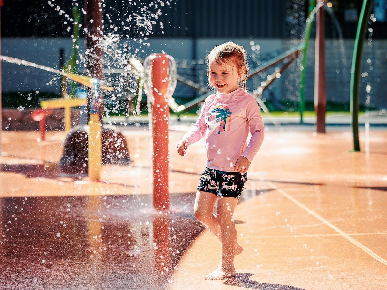Little girl in a pink top playing having water fun at the Benalla Splash Park