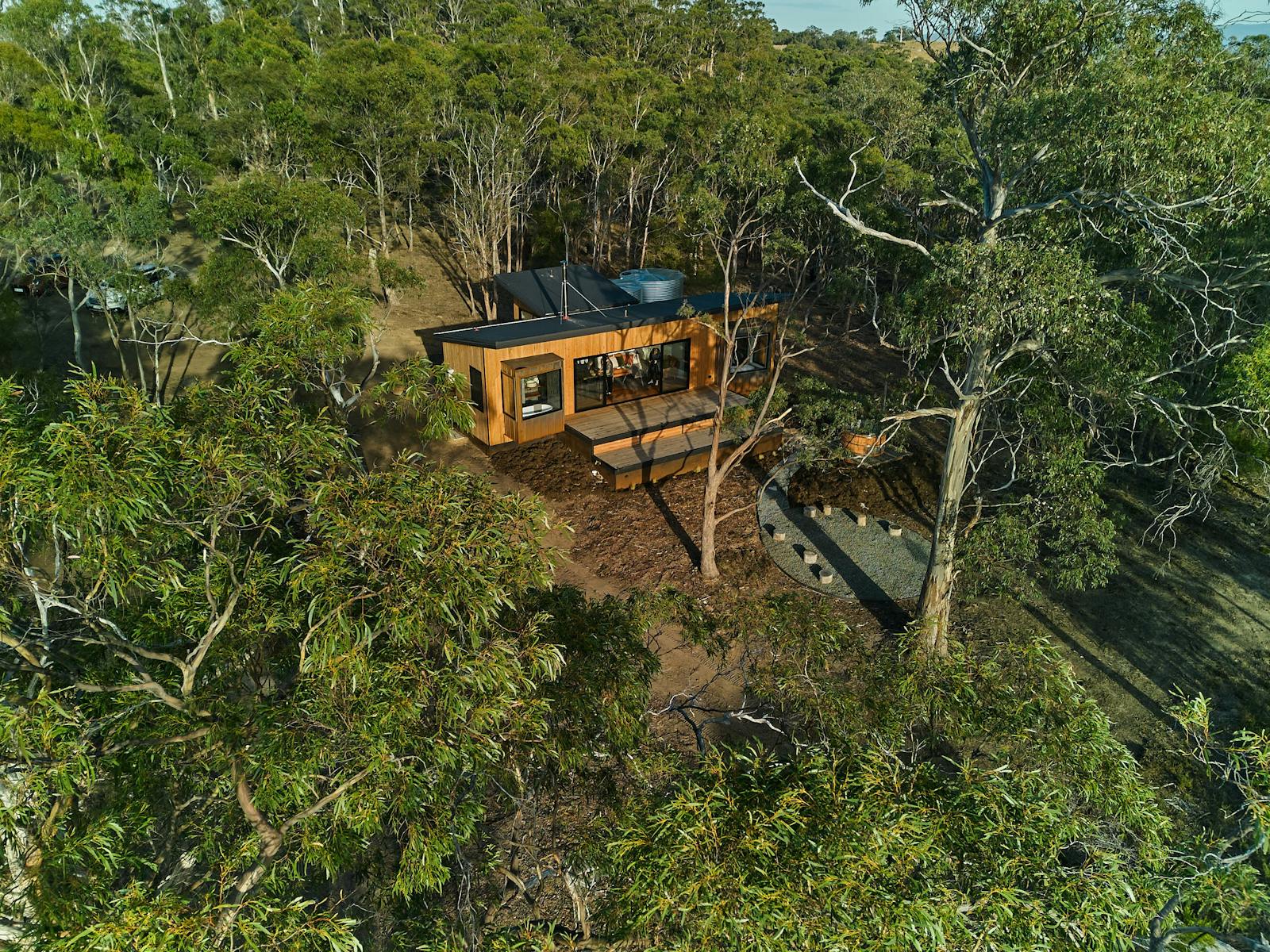 Aerial view of a timber cabin amongst the Gums