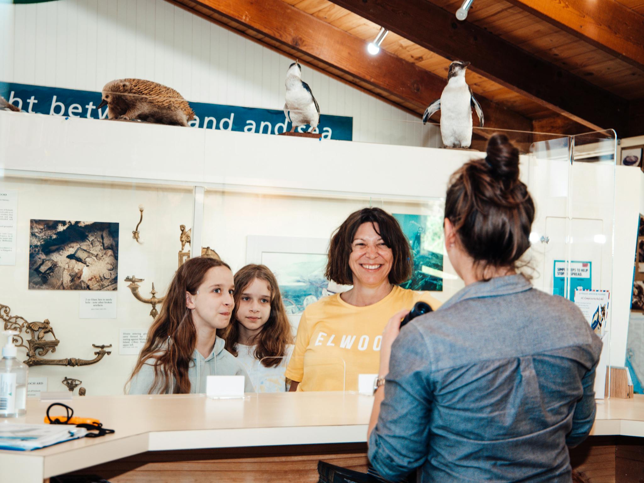 Visitors being served at the counter of the Port Campbell Visitor Information Centre