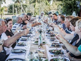People enjoying food & wine at a long table lunch part of Living the Dream wine making day
