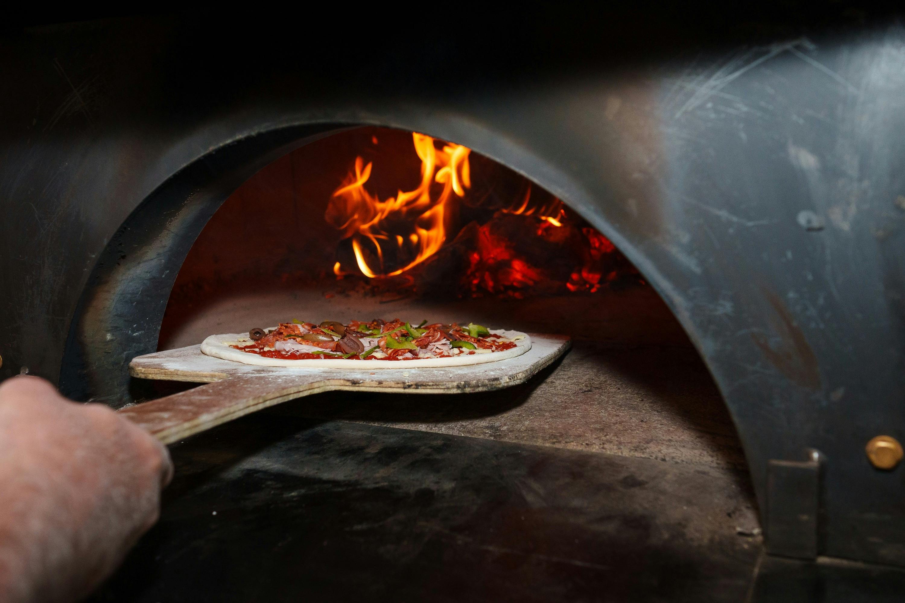 Pizza entering the woodfired oven