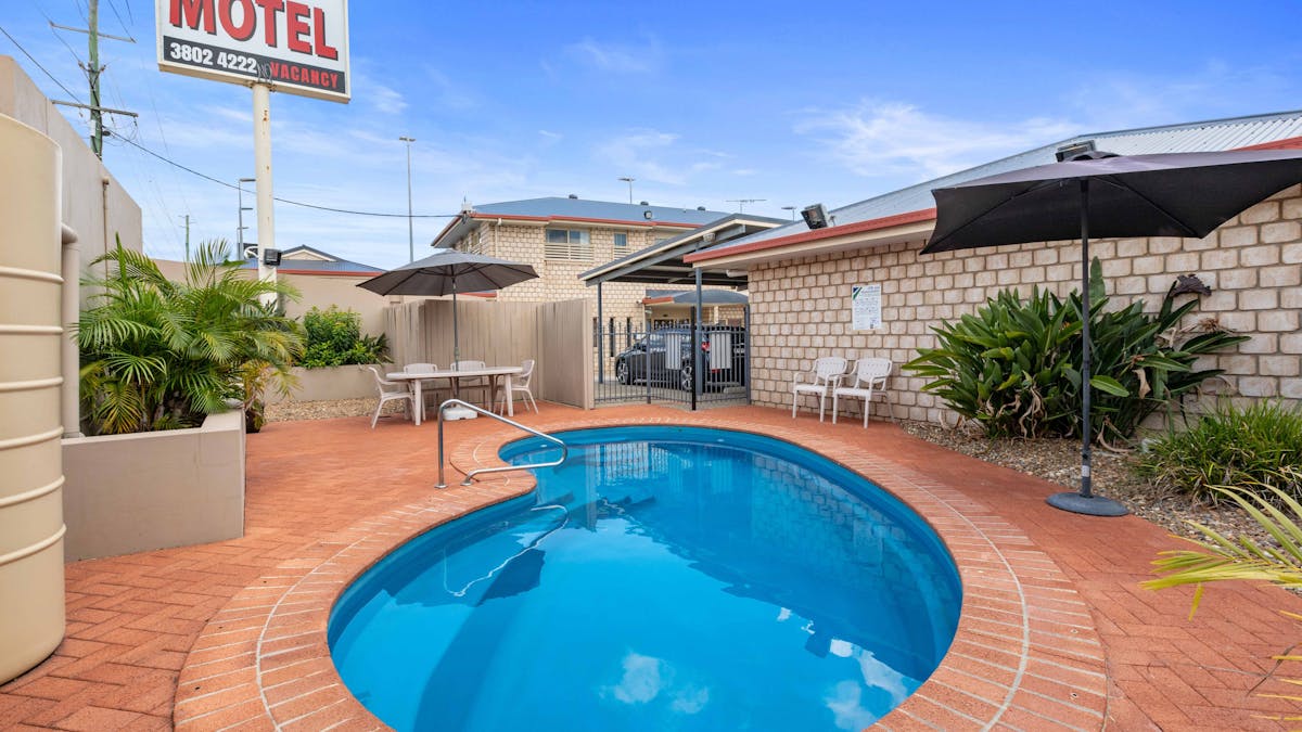 Swimming pool, motel signage and outdoor seating area