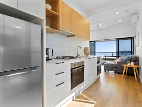 Full size stainless steel refrigerator, kitchen including coffee maker, rangehood, stovetop and more