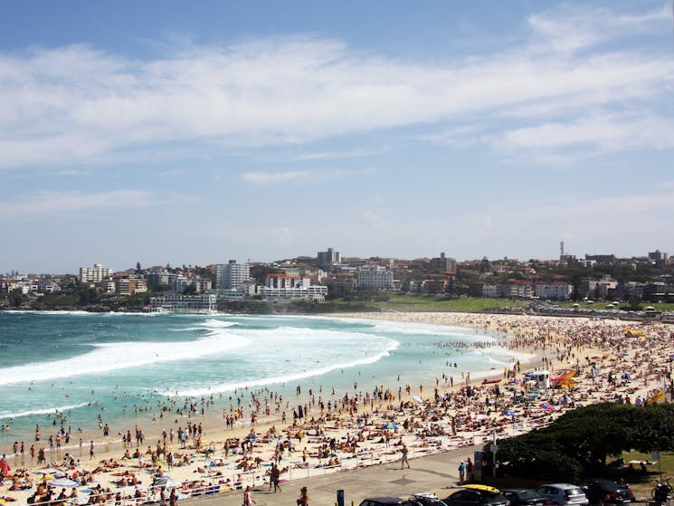 Sweeping view of the famous Bondi Beach with many people spreadout on the beach