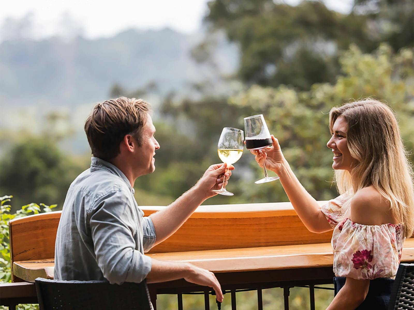 Couple drinking wine in rainforest restaurant with views