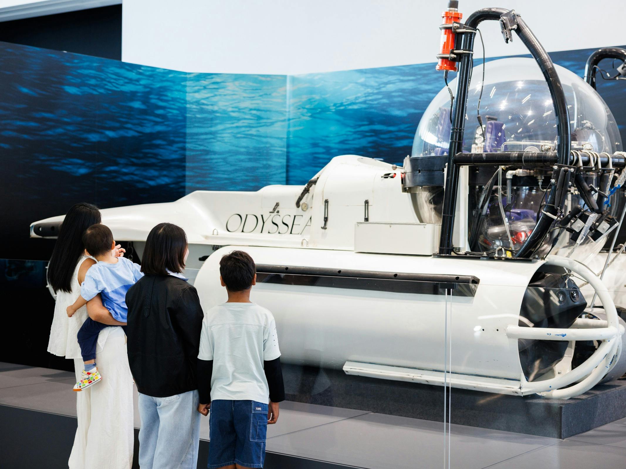 A family looks at a replica of a research vessel