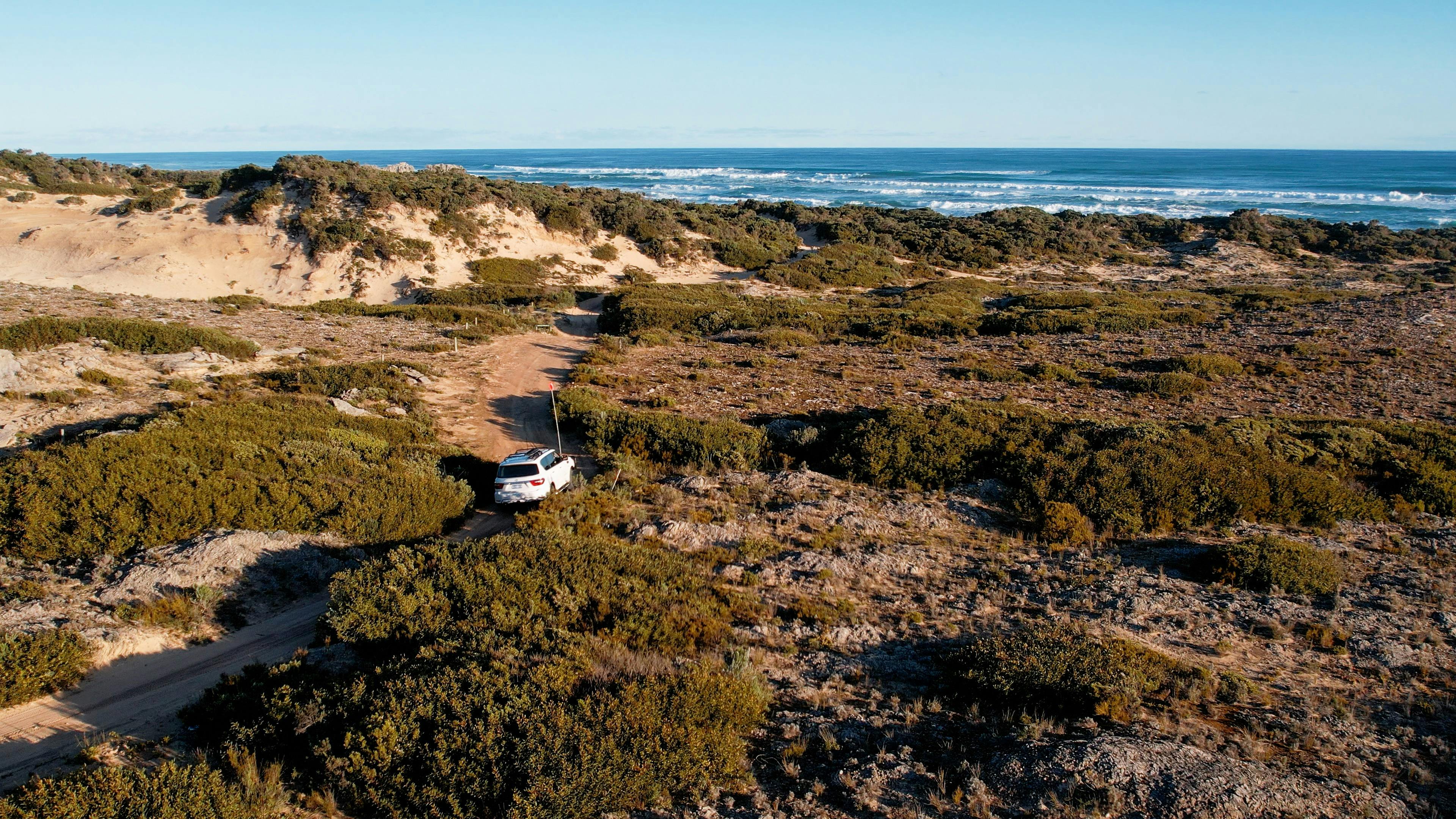 Tour Vehicle, traversing through inland terrain with the ocean in the background