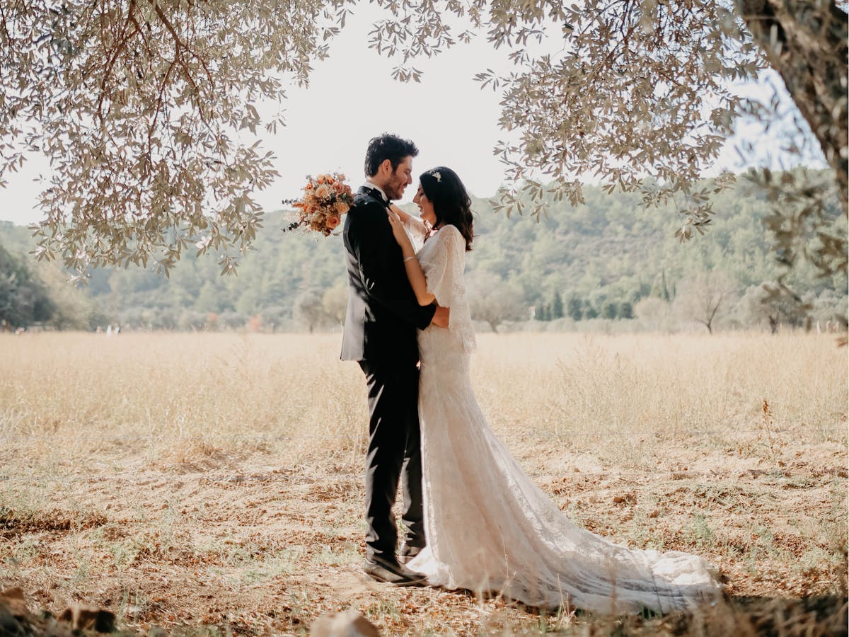 A bride and groom embrace as part of a romantic wedding scene.