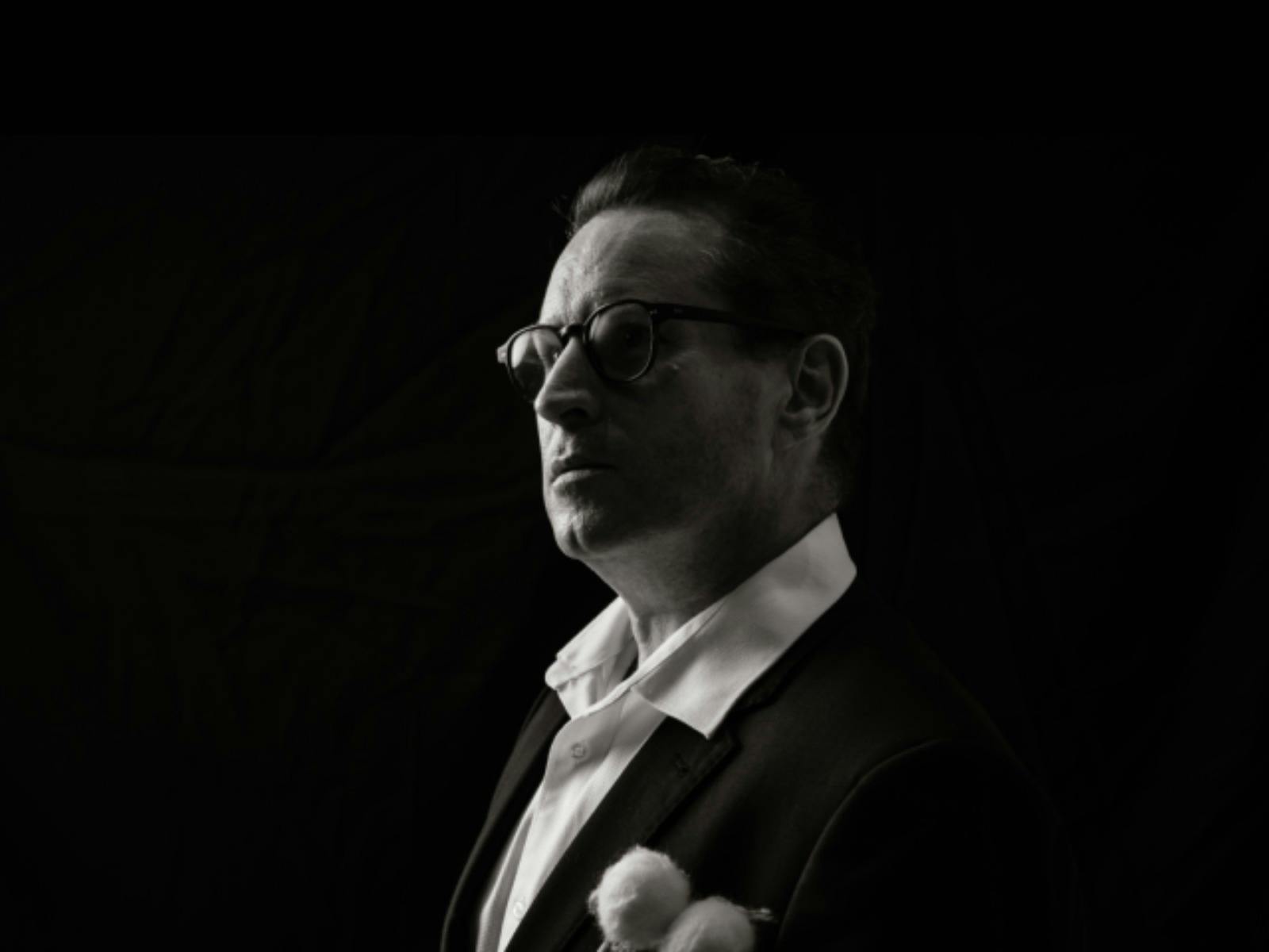 Black-and-white portrait of a timpanist in profile, looking toward the light