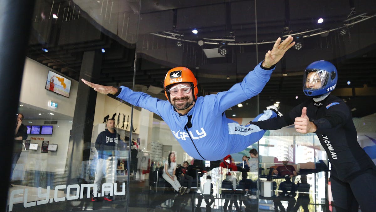 Male with a beard flies solo with arms outstretched