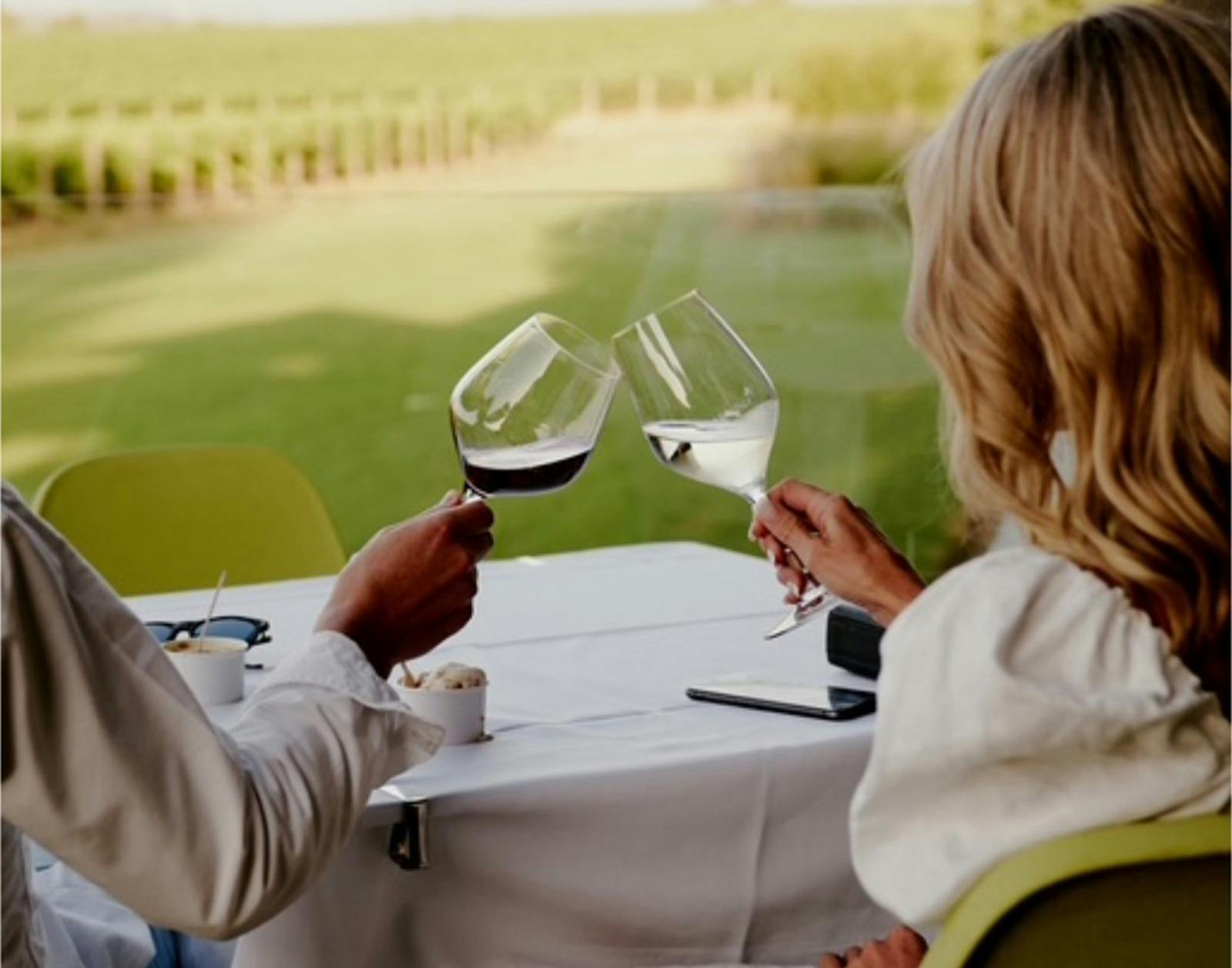 Couple viewed from the back drinking white wine overlooking Tokar winery