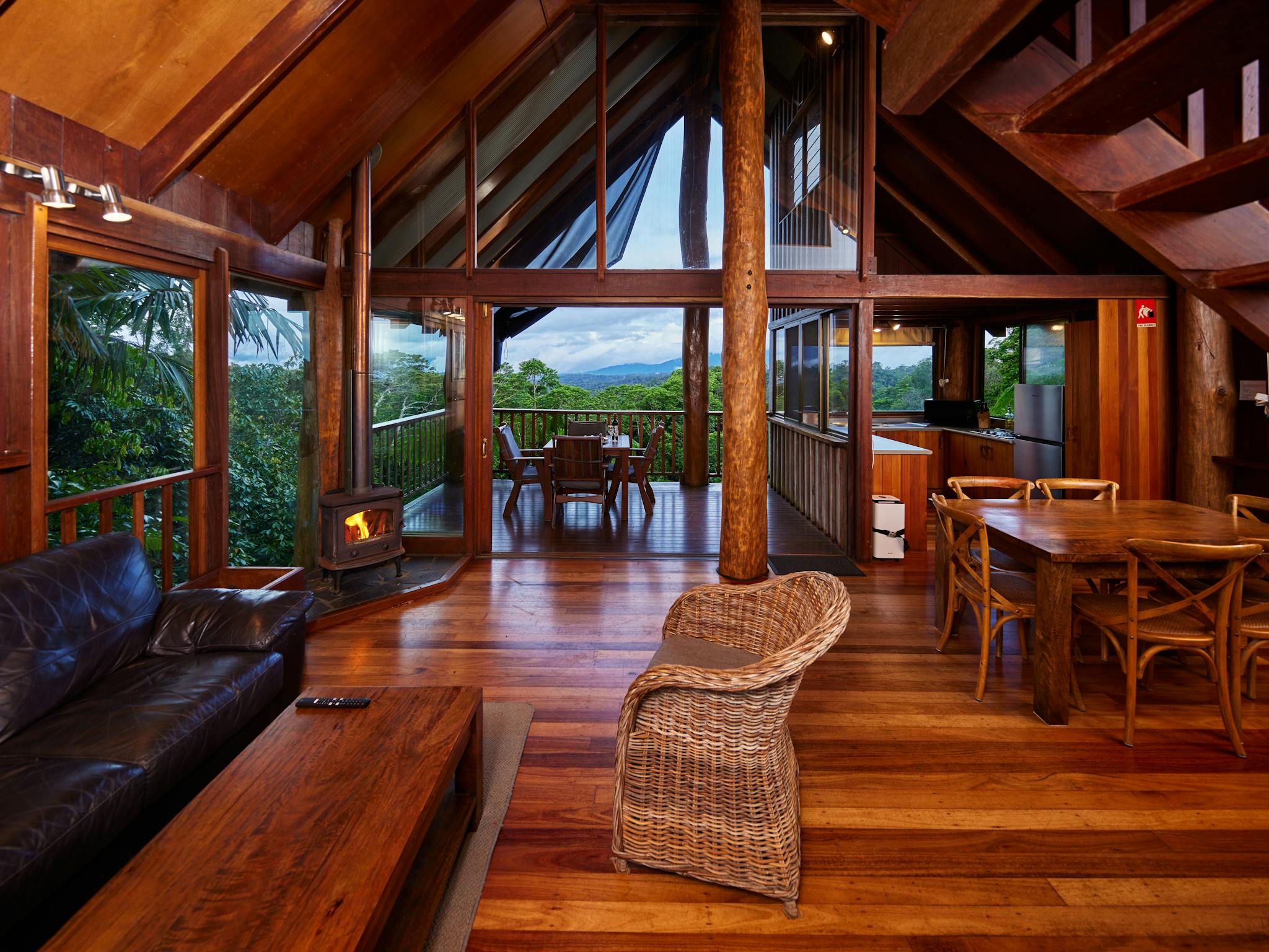 Cosy treehouse interior with fireplace and rainforest view Cosy treehouse interior with fireplace and rainforest view