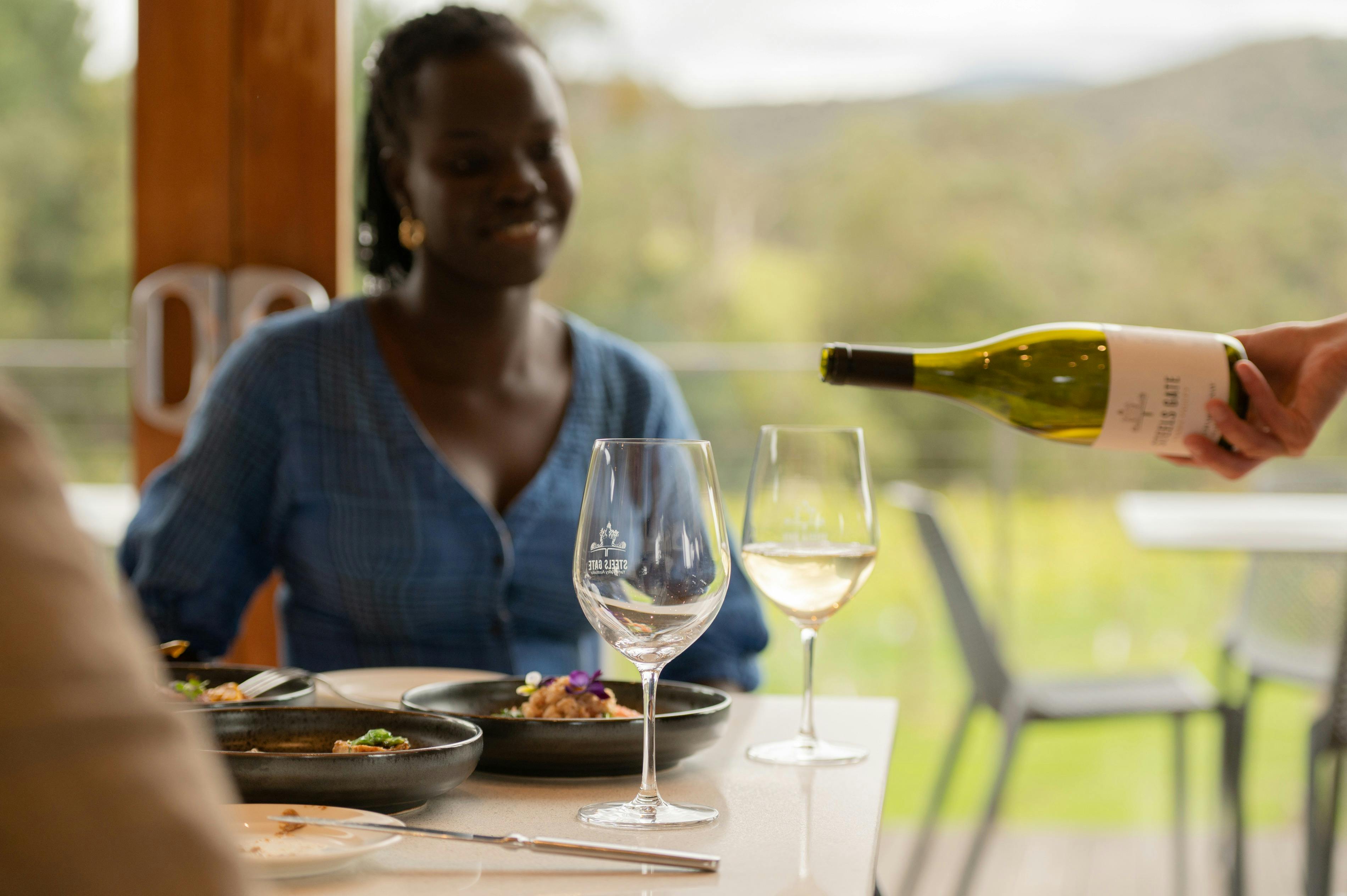 Freshly poured Steels Gate Chardonnay paired with seasonal dishes overlooking Dixons Creek vines.