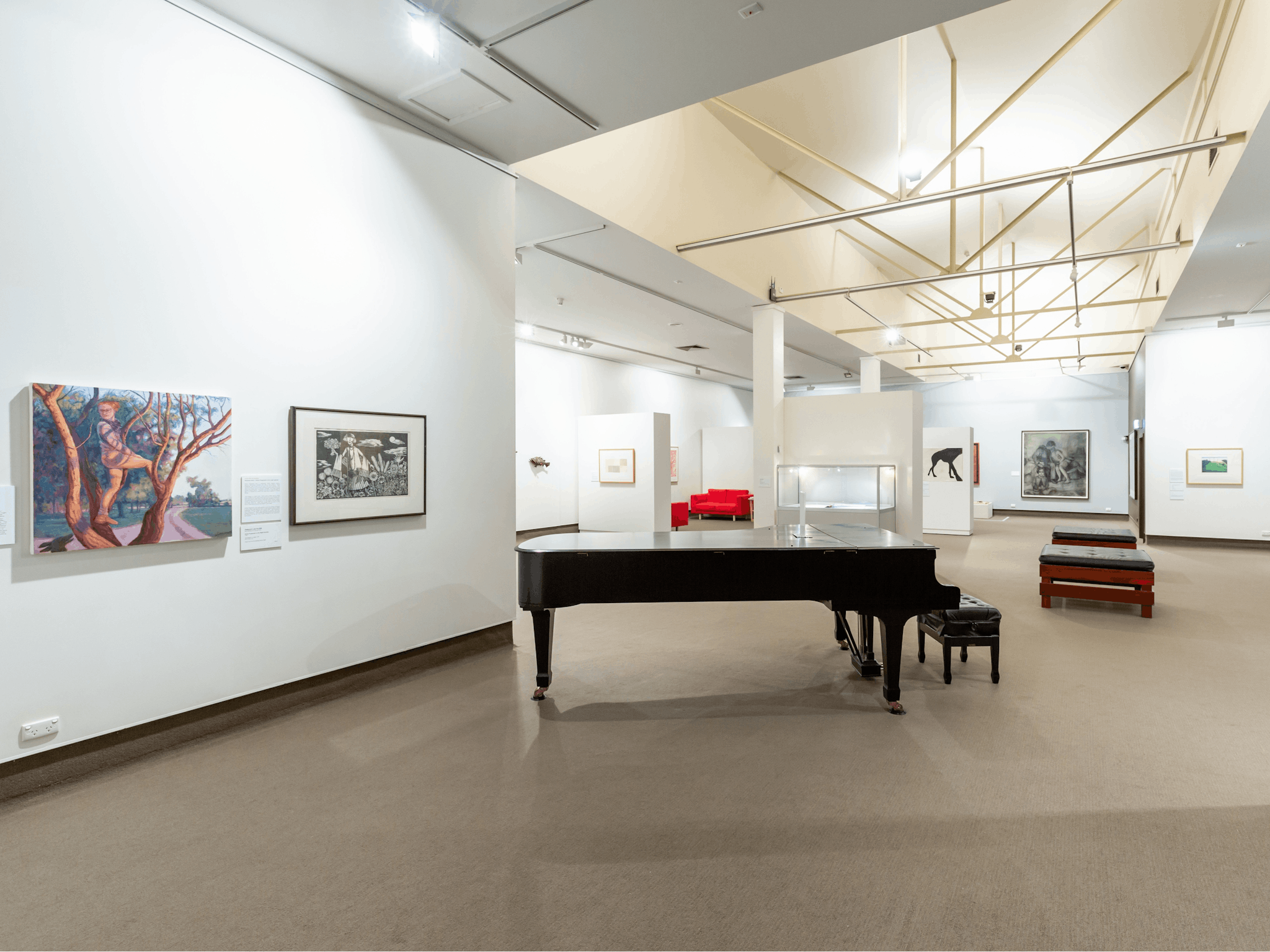 A photo of the roomy interior of the gallery with cathedral ceiling and Steinway Grand piano