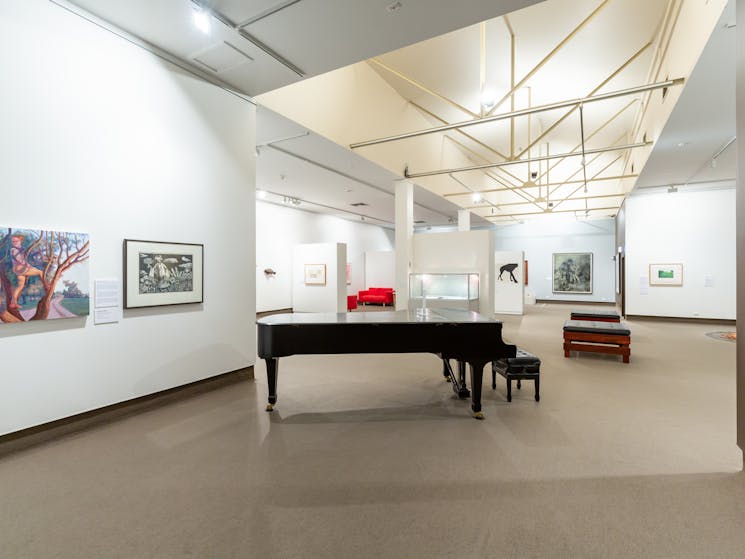 A photo of the roomy interior of the gallery with cathedral ceiling and Steinway Grand piano