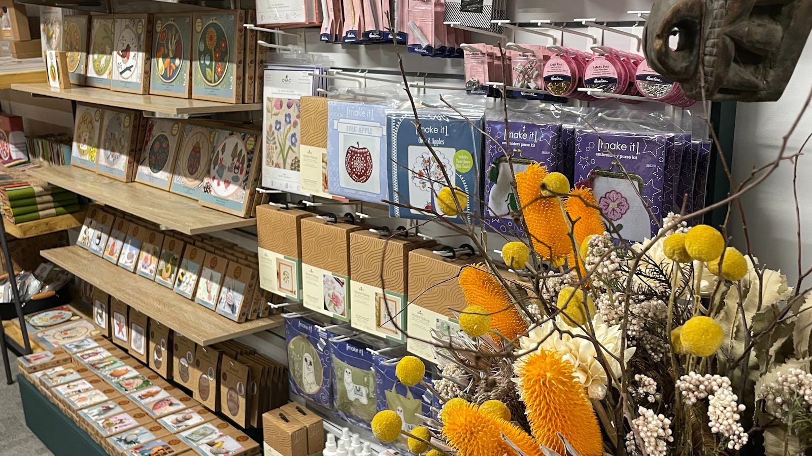 Shelves stocked with embroidery kits and haberdashery in a beautiful environment