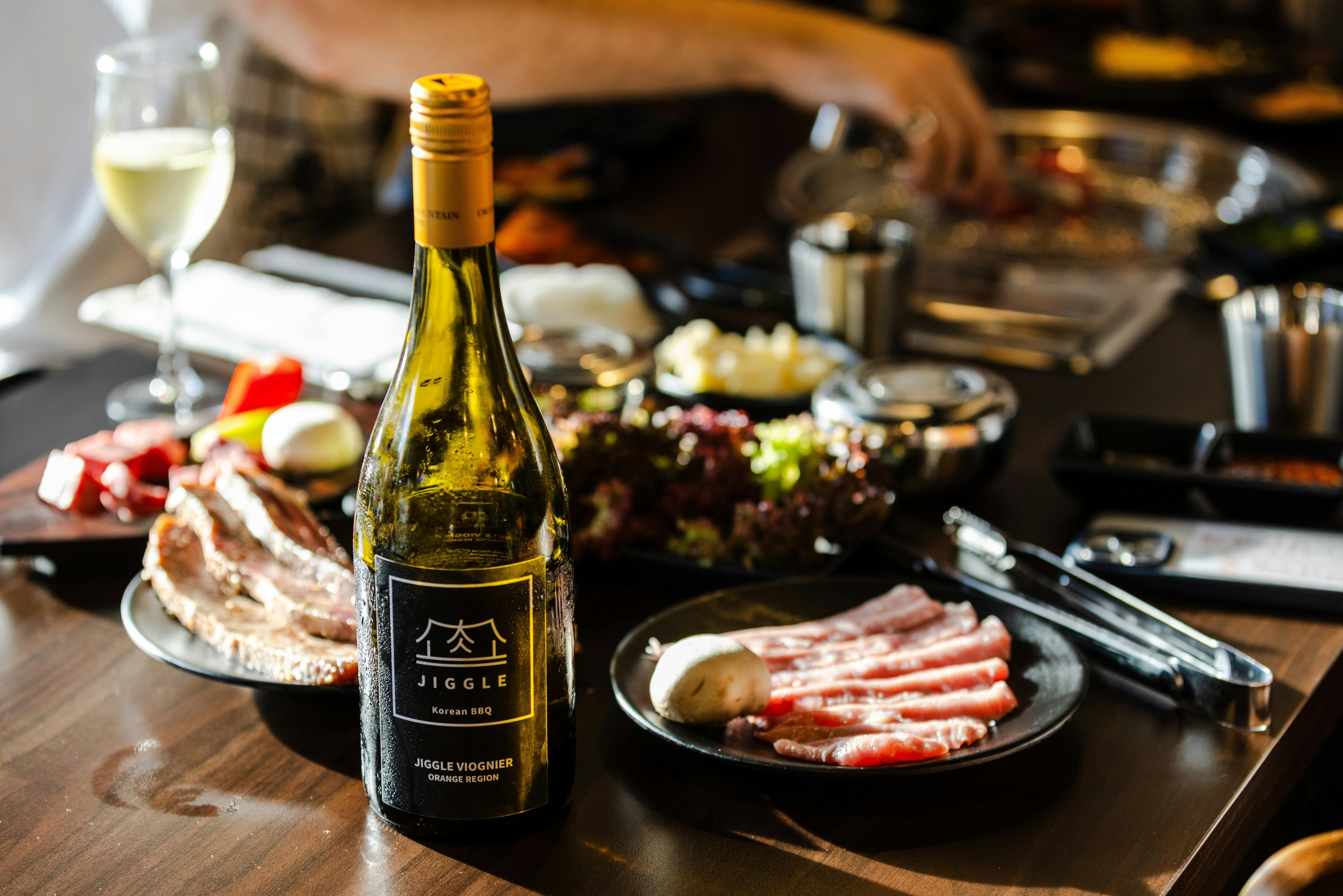 A bottle of Jiggle Viognier wine made from Orange Mountain Estate, Orange NSW on a Korean BBQ table.