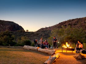 family time around the fire, enjoying sunset over the MacDonnell Ranges