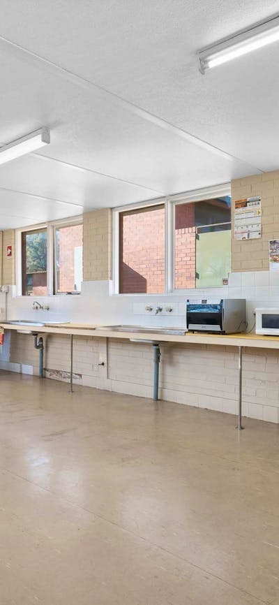 Clean and spacious shared kitchen with oven & cook tops, sink & dining tables for guests to enjoy