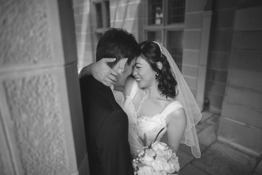 Bride and groom embracing in an archway