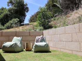 Private grassed yard with beanbags and terraced hill backdrop