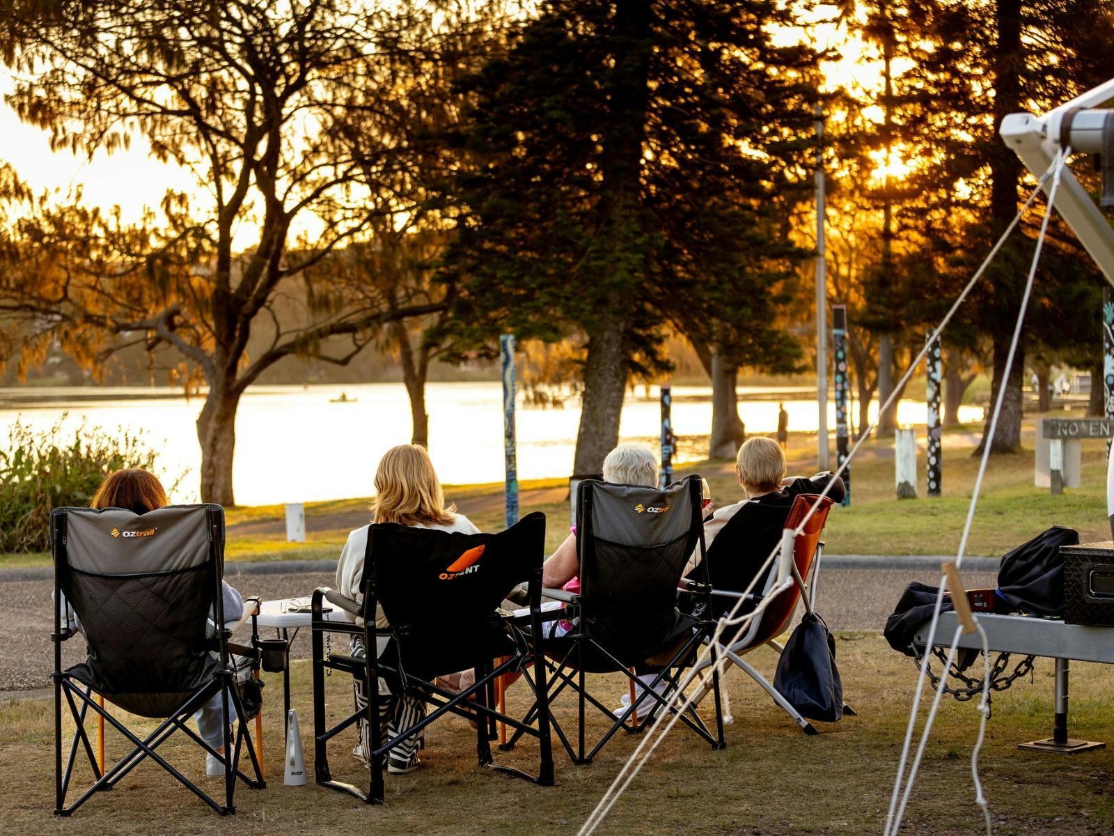 Five women in camp chairs, observing a view of the lagoon