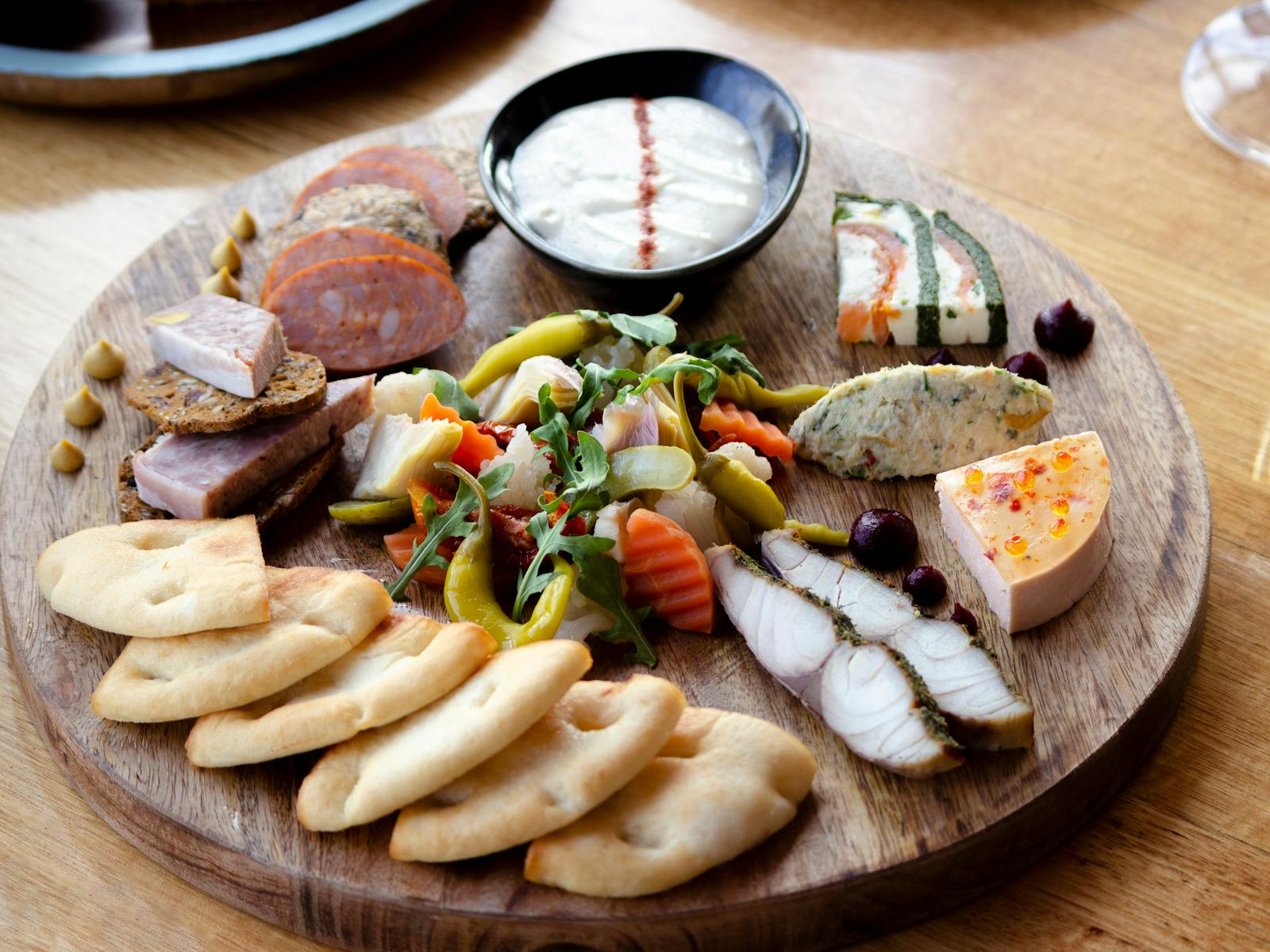 Selection of gourmet seafood antipasto presented on a wooden board at Mures Upper Deck.
