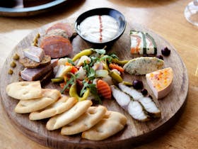 Selection of gourmet seafood antipasto presented on a wooden board at Mures Upper Deck.