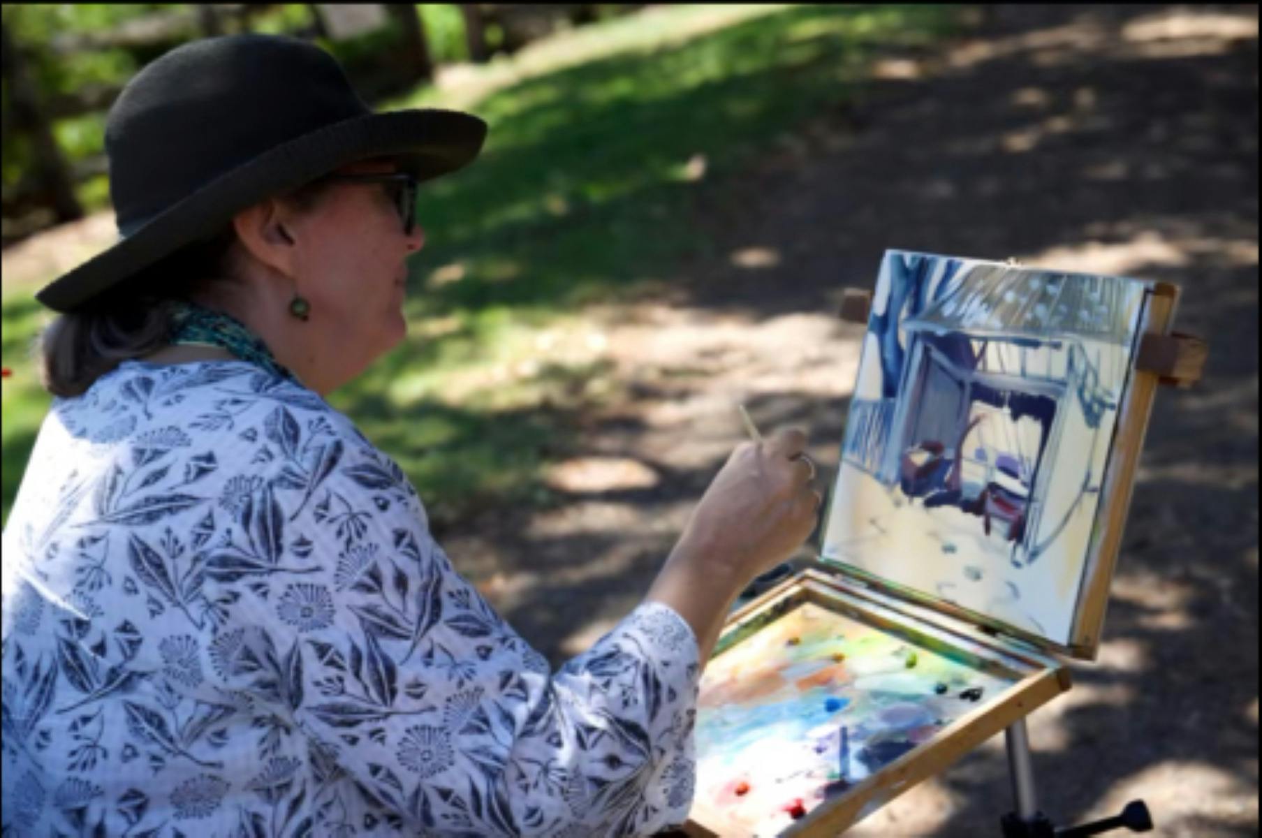 woman painting on work outdoors.