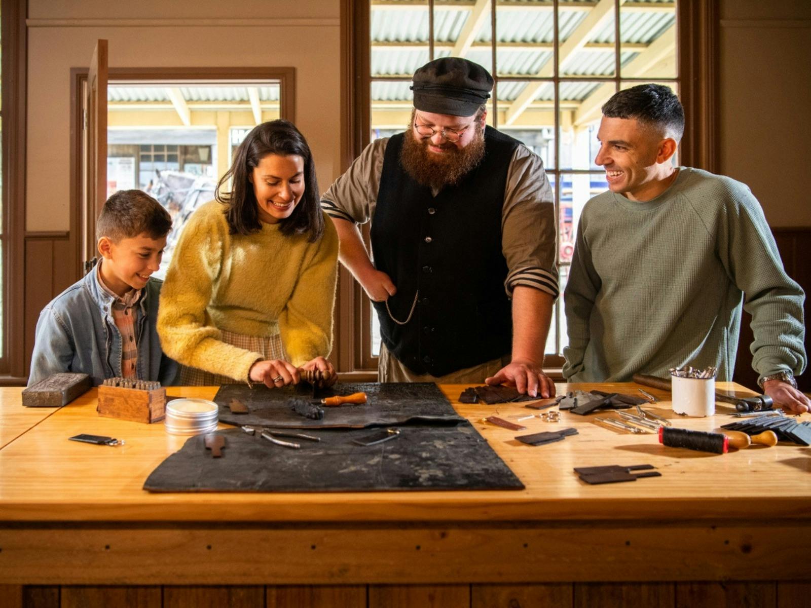 Family making keyring with Sovereign Hill leather-maker inside workshop