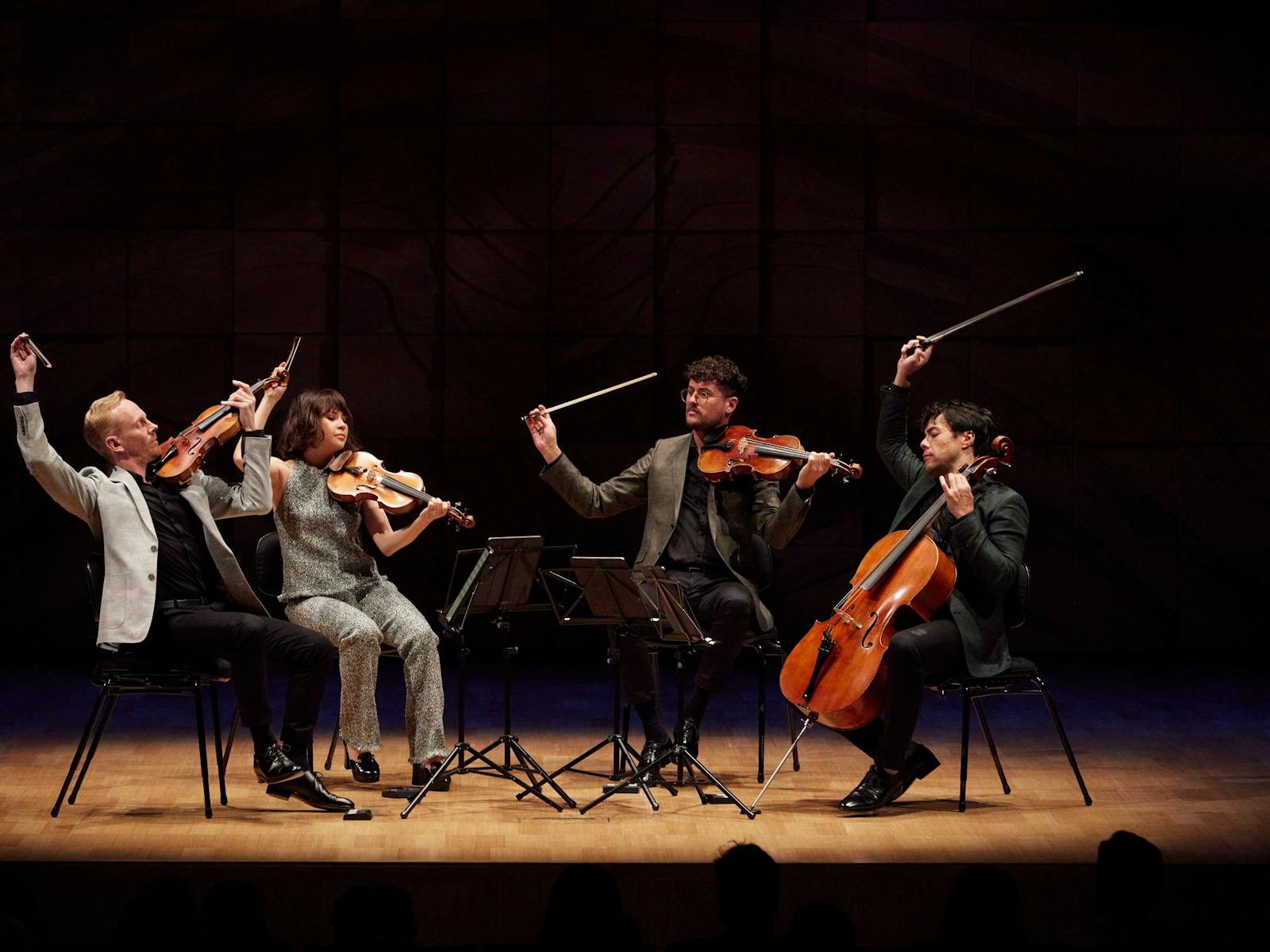 A string quartet in a spotlight on a drkened stage