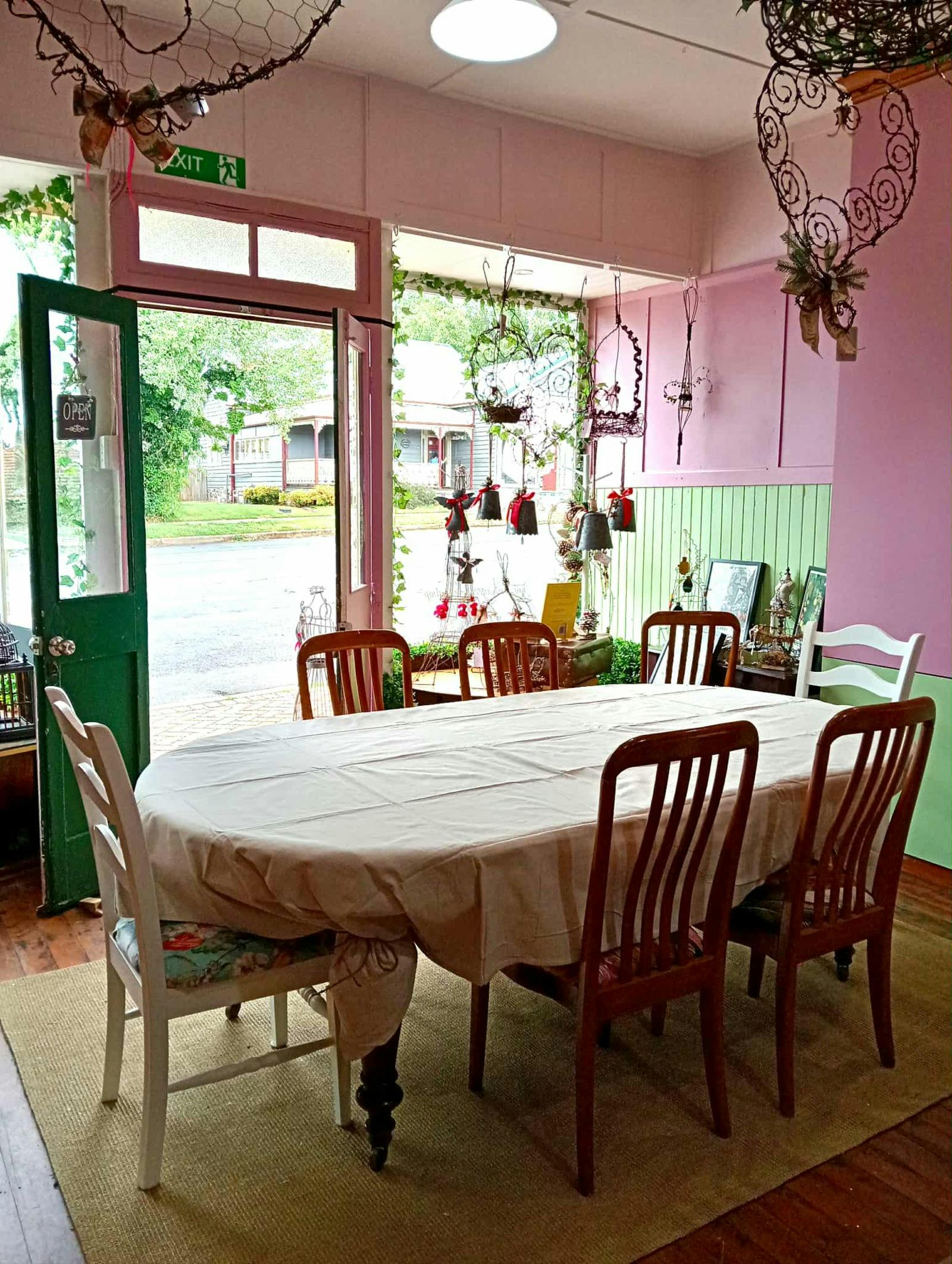 Iterior of the studio with a pink and mint green colour scheme. Large oval worktable with chairs.