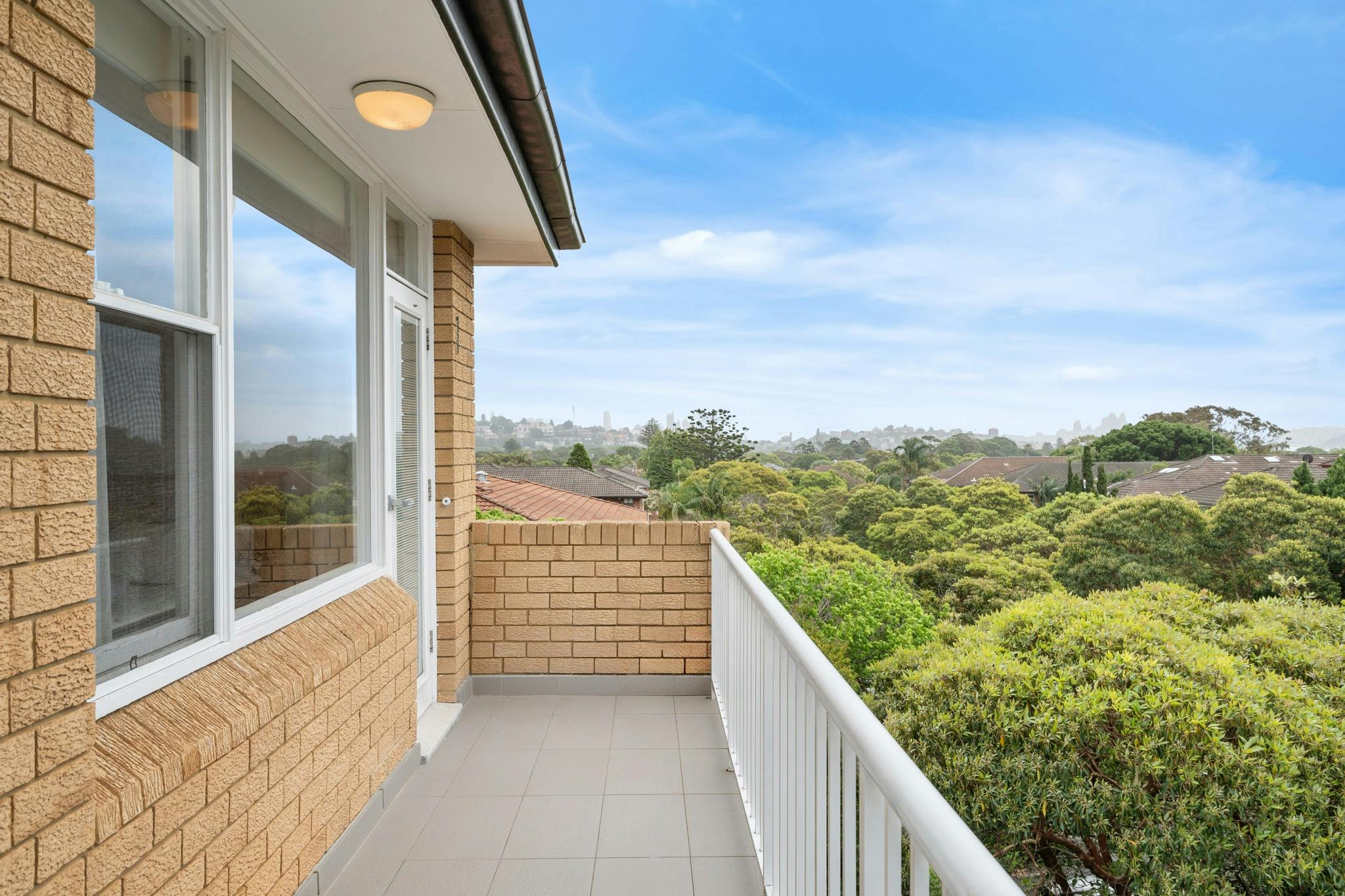 寬敞的陽台可欣賞樹木和雪梨天際線的全景。